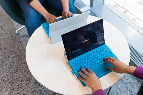 Table basse et ronde composée de de 2 ordianteurs bleus, l'écran laisse apercevoir l'utilisation d'un CMS. L'agence JVFlex utilise cette photo afin d'imager l'offre de création de site internet via un CMS. October un CMF avec une interface interactive pour les utilisateurs.